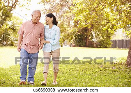 Senior Asian Couple Walking Through Park Together View Large Photo Image Stock Photo - Senior Asian Couple Walking Through Park Together. Fotosearch