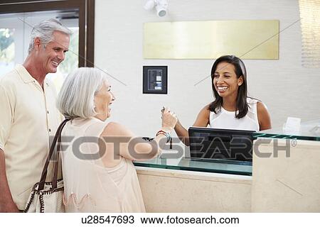 Senior Couple Checking In At Hotel Reception View Large Photo Image Stock Image - Senior Couple Checking In At Hotel Reception. Fotosearch