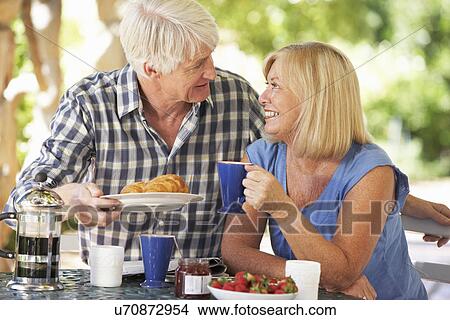 Senior couple eating breakfast outdoors View Large Photo Image Picture - Senior couple eating breakfast outdoors. Fotosearch