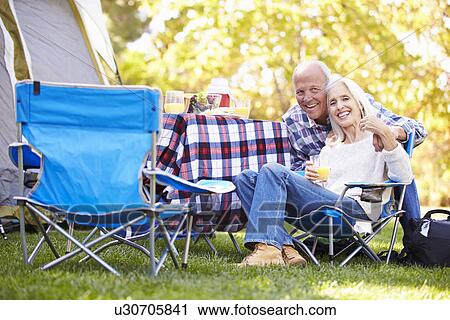 Stock Image - Senior Couple Enjoying Camping Holiday In Countryside. Fotosearch