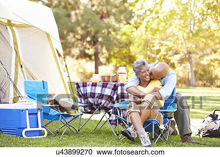 Stock Image - Senior Couple Enjoying Camping Holiday In Countryside. Fotosearch