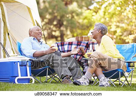 Stock Photo - Senior Couple Enjoying Camping Holiday In Countryside. Fotosearch
