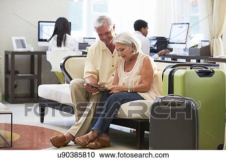Senior Couple In Hotel Lobby Looking At Digital Tablet View Large Photo Image Stock Image - Senior Couple In Hotel Lobby Looking At Digital Tablet. Fotosearch