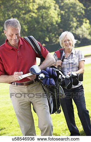 Stock Photograph - Senior couple on golf course. Fotosearch