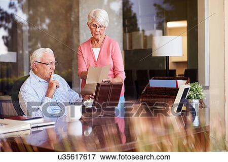 Stock Photo - Senior Couple Putting Letter Into Keepsake Box. Fotosearch