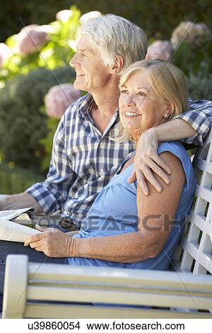 Picture - Senior couple reading in garden. Fotosearch