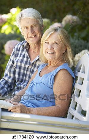 Senior couple reading in garden View Large Photo Image Stock Image - Senior couple reading in garden. Fotosearch