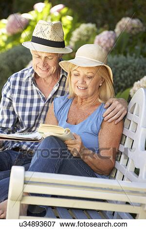 Stock Photo - Senior couple reading in garden. Fotosearch