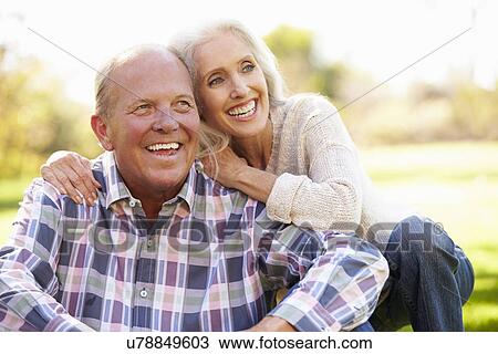 Stock Image - Senior Couple Relaxing In Autumn Landscape. Fotosearch