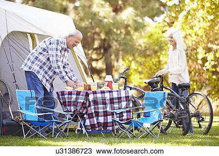 Senior Couple Riding Bikes On Camping Holiday In Countryside View Large Photo Image Stock Image - Senior Couple Riding Bikes On Camping Holiday In Countryside. Fotosearch