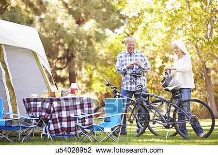 Senior Couple Riding Bikes On Camping Holiday In Countryside View Large Photo Image Stock Image - Senior Couple Riding Bikes On Camping Holiday In Countryside. Fotosearch