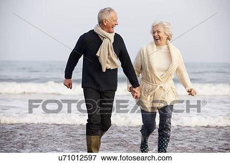 Senior Couple Running Along Winter Beach View Large Photo Image Stock Photo - Senior Couple Running Along Winter Beach. Fotosearch