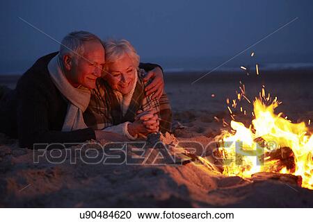 Senior Couple Sitting By Fire On Winter Beach View Large Photo Image Stock Image - Senior Couple Sitting By Fire On Winter Beach . Fotosearch