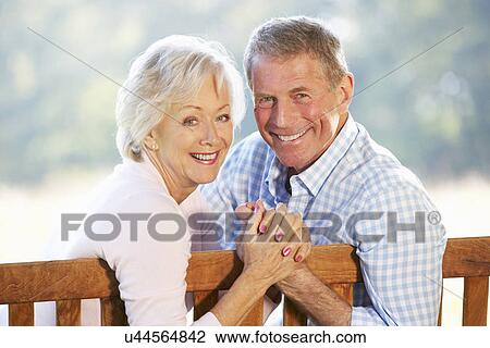 Stock Image - Senior couple sitting outdoors. Fotosearch
