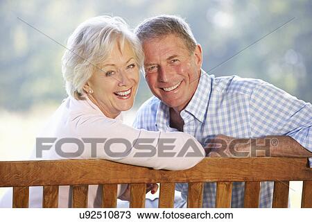 Stock Image - Senior couple sitting outdoors. Fotosearch