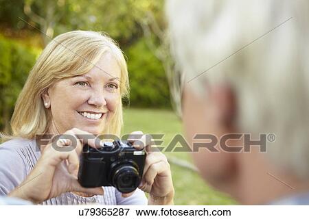 Stock Photo - Senior couple taking photo outdoors. Fotosearch