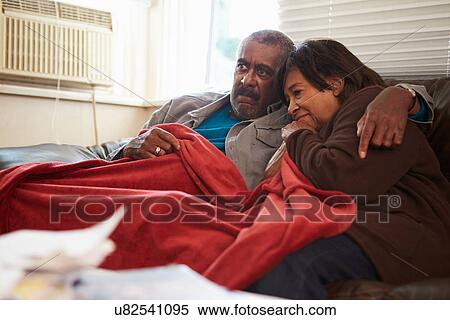 Senior Couple Trying To Keep Warm Under Blanket At Home View Large Photo Image Stock Photography - Senior Couple Trying To Keep Warm Under Blanket At Home. Fotosearch