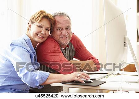 Stock Image - Senior Couple Using Computer At Home. Fotosearch