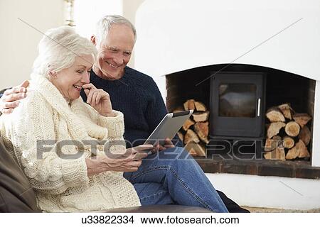 Senior Couple Using Digital Tablet On Sofa View Large Photo Image Picture - Senior Couple Using Digital Tablet On Sofa . Fotosearch