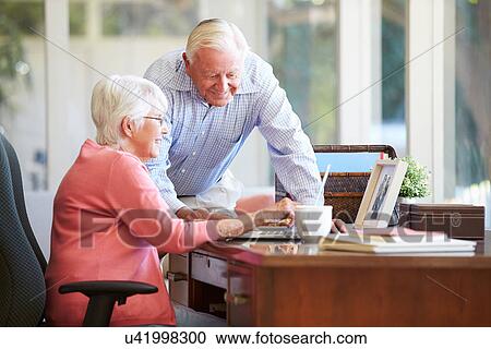 Senior Couple Using Laptop On Desk At Home View Large Photo Image Stock Image - Senior Couple Using Laptop On Desk At Home. Fotosearch