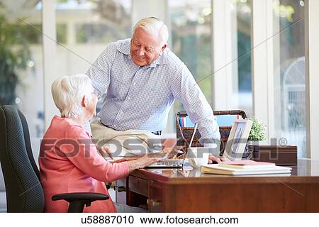 Senior Couple Using Laptop On Desk At Home View Large Photo Image Stock Image - Senior Couple Using Laptop On Desk At Home. Fotosearch