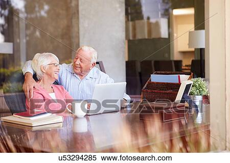 Senior Couple Using Laptop On Desk At Home View Large Photo Image Stock Photography - Senior Couple Using Laptop On Desk At Home. Fotosearch