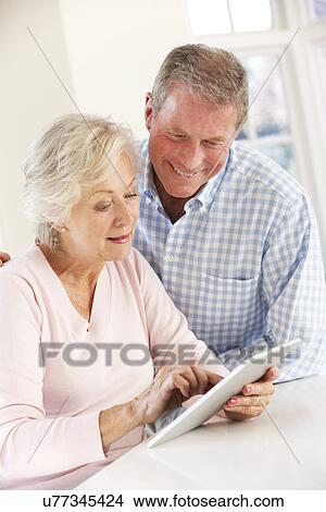 Senior couple using tablet at home View Large Photo Image Picture - Senior couple using tablet at home. Fotosearch