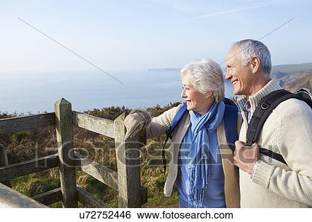 Stock Photograph - Senior Couple Walking Along Coastal Path. Fotosearch