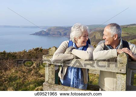 Stock Photography - Senior Couple Walking Along Coastal Path. Fotosearch
