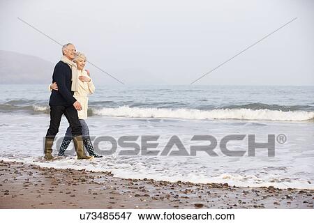 Senior Couple Walking Along Winter Beach View Large Photo Image Stock Photo - Senior Couple Walking Along Winter Beach. Fotosearch