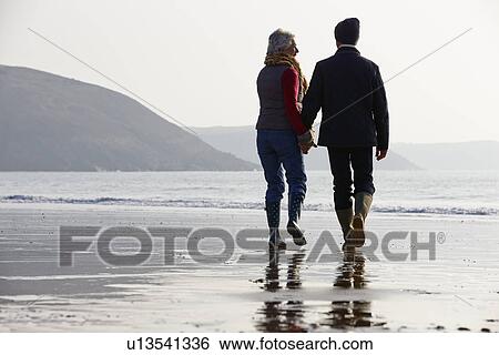 Senior Couple Walking Along Winter Beach View Large Photo Image Stock Photograph - Senior Couple Walking Along Winter Beach. Fotosearch