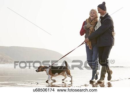 Senior Couple Walking Along Winter Beach With Pet Dog View Large Photo Image Picture - Senior Couple Walking Along Winter Beach With Pet Dog. Fotosearch
