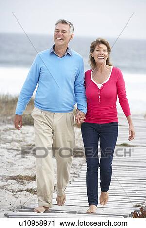 Senior couple walking by the sea View Large Photo Image Stock Image - Senior couple walking by the sea. Fotosearch