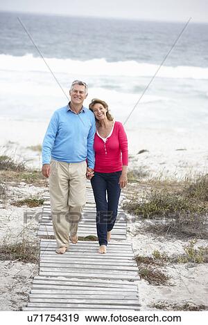 Senior couple walking by the sea View Large Photo Image Stock Photo - Senior couple walking by the sea. Fotosearch