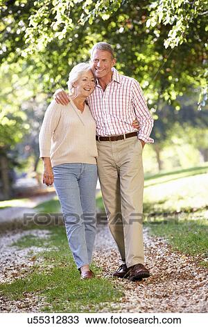 Senior couple walking in park View Large Photo Image Stock Image - Senior couple walking in park. Fotosearch