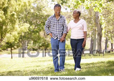 Stock Photo - Senior couple walking in park. Fotosearch