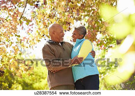 Senior Couple Walking Through Autumn Woodland View Large Photo Image Picture - Senior Couple Walking Through Autumn Woodland. Fotosearch