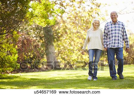 Stock Photo - Senior Couple Walking Through Autumn Woodland. Fotosearch