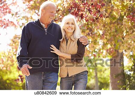 Senior Couple Walking Through Autumn Woodland View Large Photo Image Stock Photo - Senior Couple Walking Through Autumn Woodland. Fotosearch