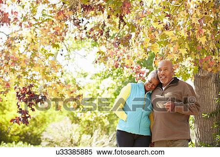 Senior Couple Walking Through Autumn Woodland View Large Photo Image Stock Photography - Senior Couple Walking Through Autumn Woodland. Fotosearch