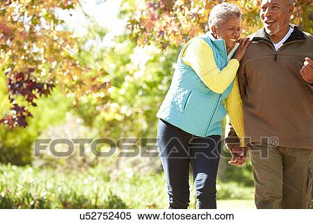 Senior Couple Walking Through Autumn Woodland View Large Photo Image Stock Photography - Senior Couple Walking Through Autumn Woodland. Fotosearch