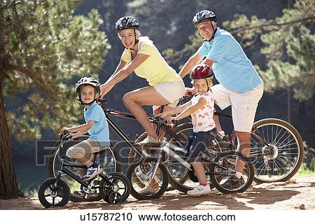 Stock Image - Senior couple with grandchildren on country bike ride. Fotosearch