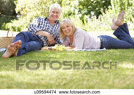 Picture - Senior couple with picnic in park. Fotosearch