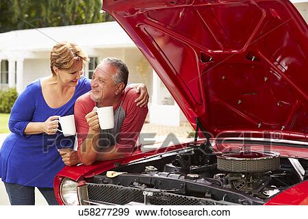 Stock Photo - Senior Couple With Restored Classic Car. Fotosearch
