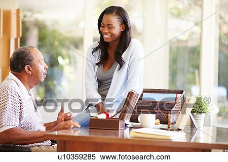 Stock Photography - Senior Father Discussing Document With Adult Daughter. Fotosearch