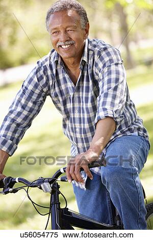 Stock Photography - Senior man cycling in park. Fotosearch