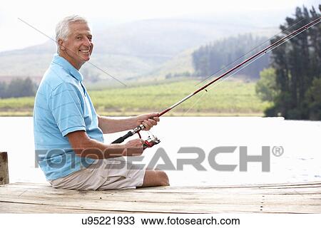 Stock Image - Senior man fishing on jetty. Fotosearch