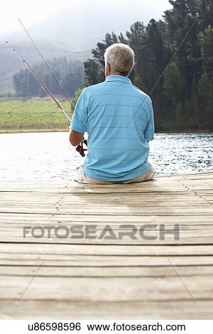 Senior man fishing on jetty View Large Photo Image Stock Photograph - Senior man fishing on jetty. Fotosearch