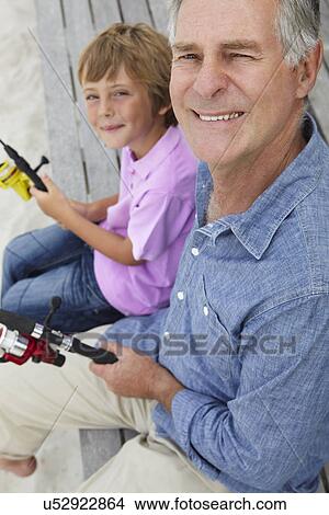 Picture - Senior man fishing with grandson. Fotosearch