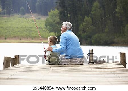 Picture - Senior man fishing with grandson. Fotosearch